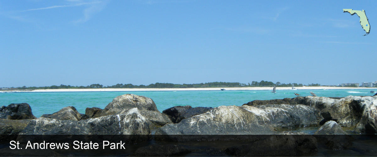 Looking over the rocks and blue water at St. Andrews State Park in Bay County, Florida