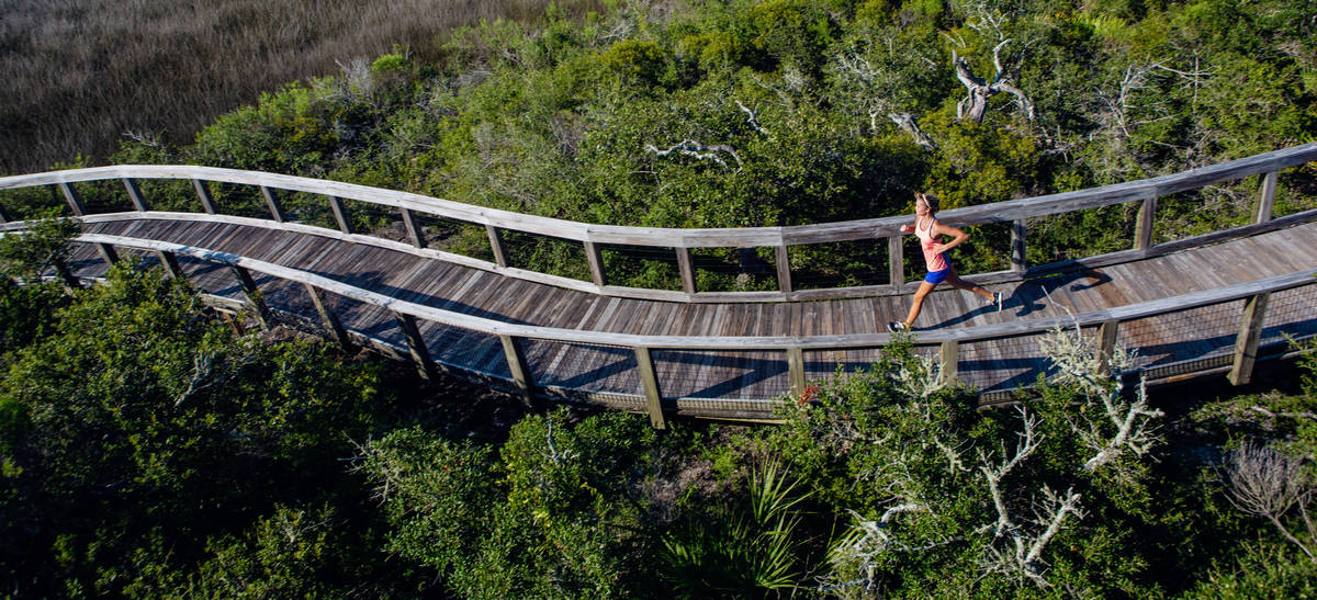 Woman running on a boardwalk at Big Lagoon State Park