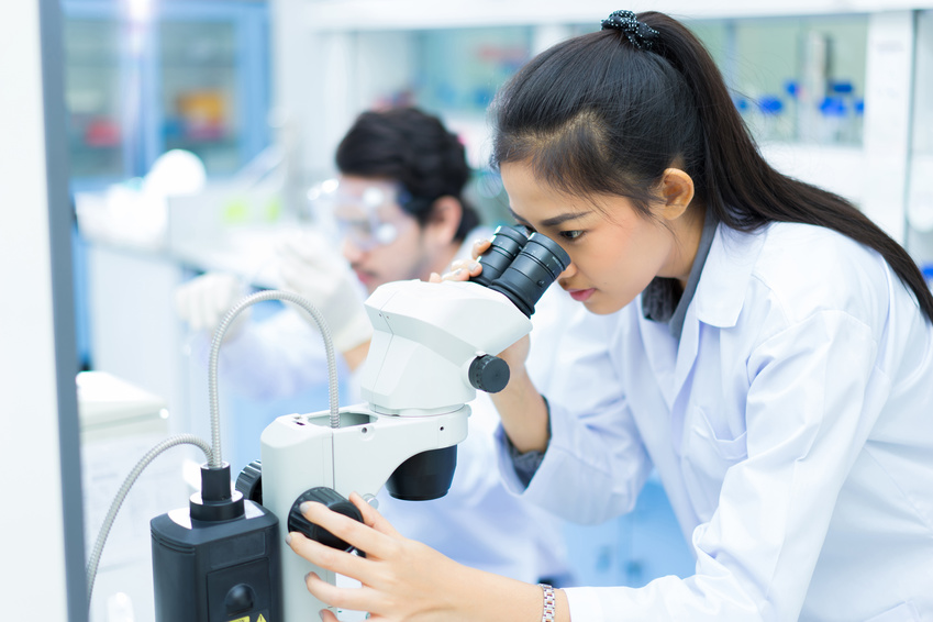 Scientists working at a laboratory - Woman uses microscope