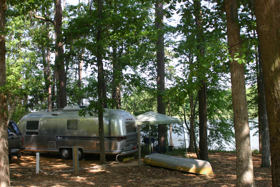 A silver airstream RV next to the river at Three Rivers State Park