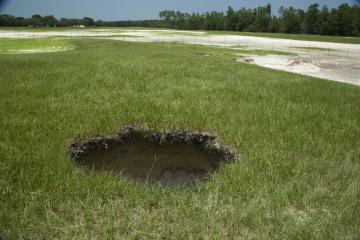 A sinkhole in a field.