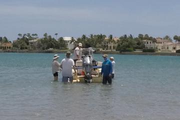 A view of people in the water beside a boat at Jupiter Inlet