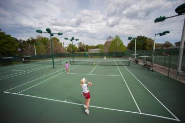 A woman serving a ball on a tennis county at Fort Gatlin in Orange Couty, Florida