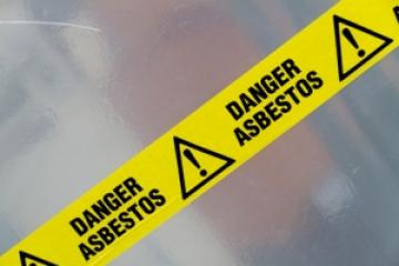 Yellow warning tape with Danger Asbestos printed on it