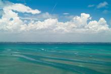 Water on a clear day with fluffy clouds