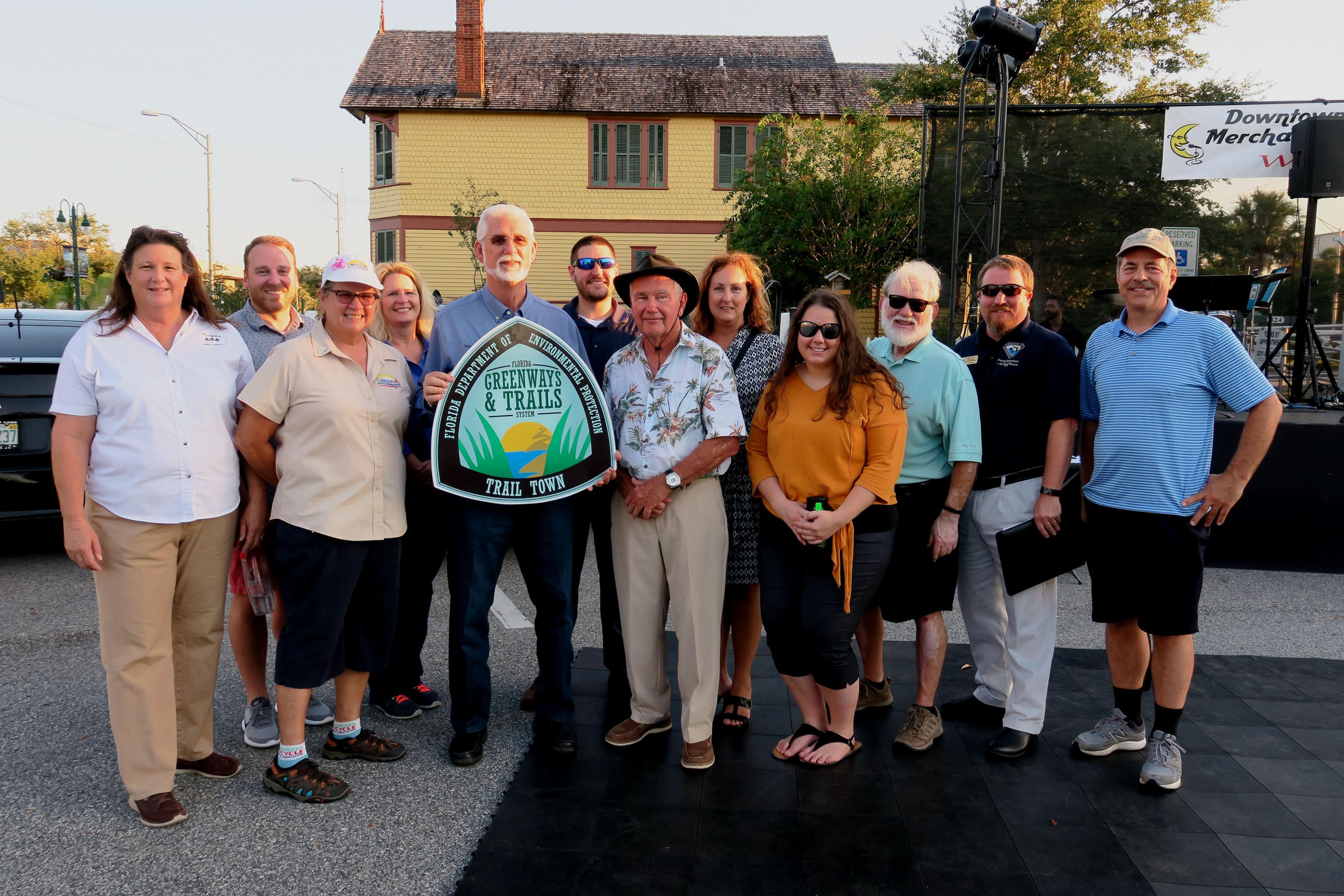 Titusville Mayor Walt Johnson (holding sign) with city staff, OGT staff, and Greenways and Trails Council members at Titusville event, OGT